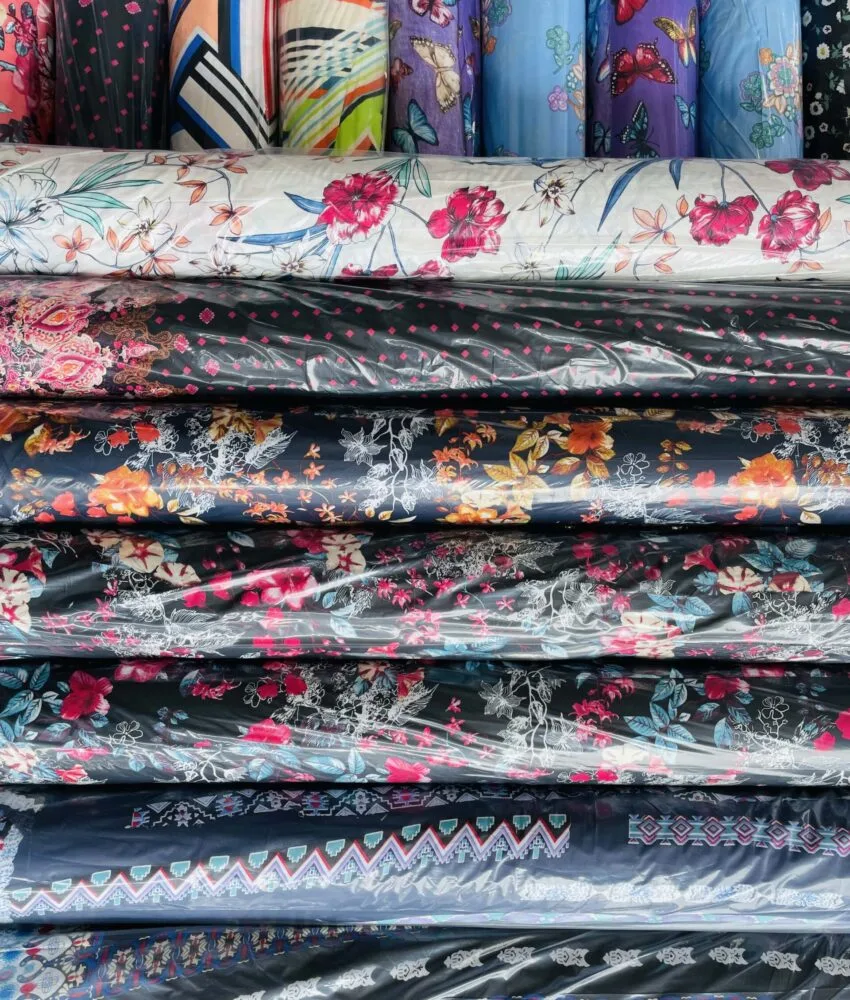 Close-up of fabric rolls in various colors and textures, displaying a wide selection of premium textiles for fashion and design.