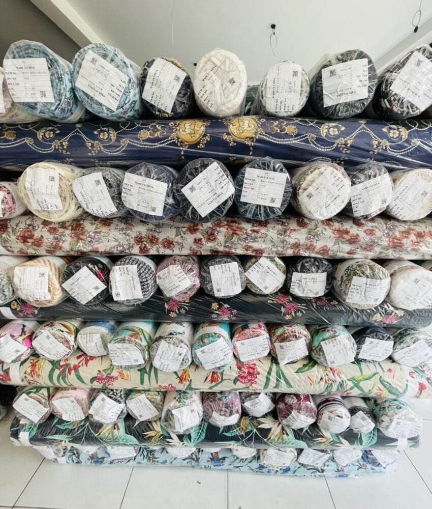 Close-up of fabric rolls in various colors and textures, displaying a wide selection of premium textiles for fashion and design.