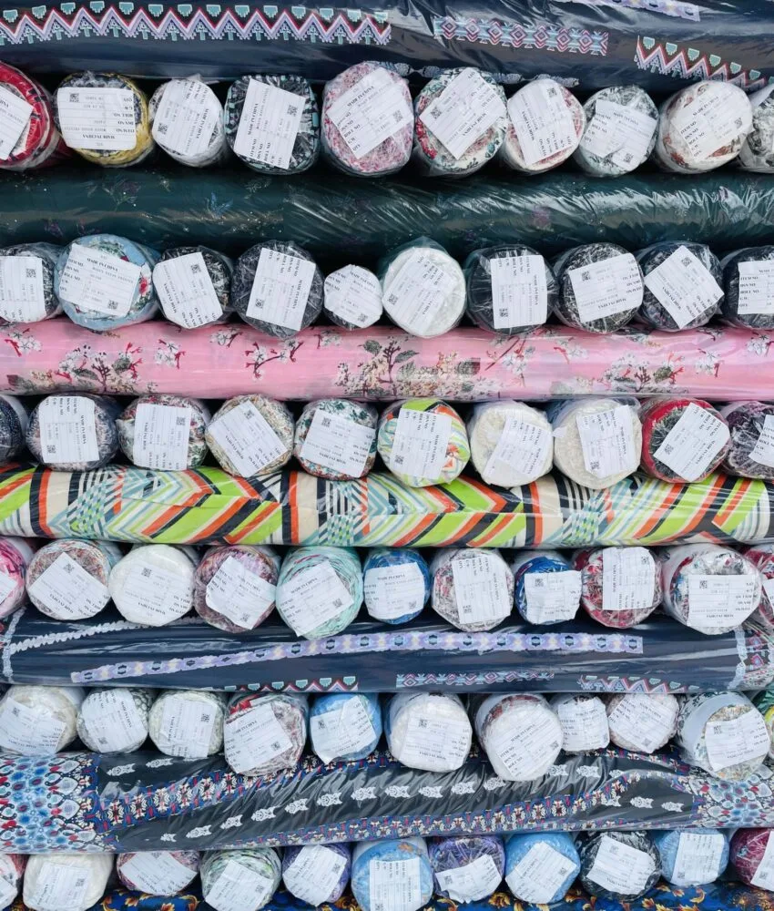 Close-up of fabric rolls in various colors and textures, displaying a wide selection of premium textiles for fashion and design.