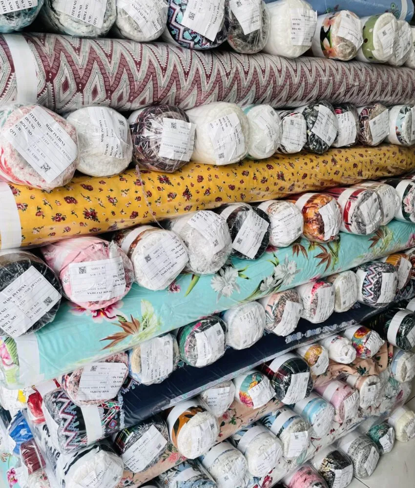 Close-up of fabric rolls in various colors and textures, displaying a wide selection of premium textiles for fashion and design.