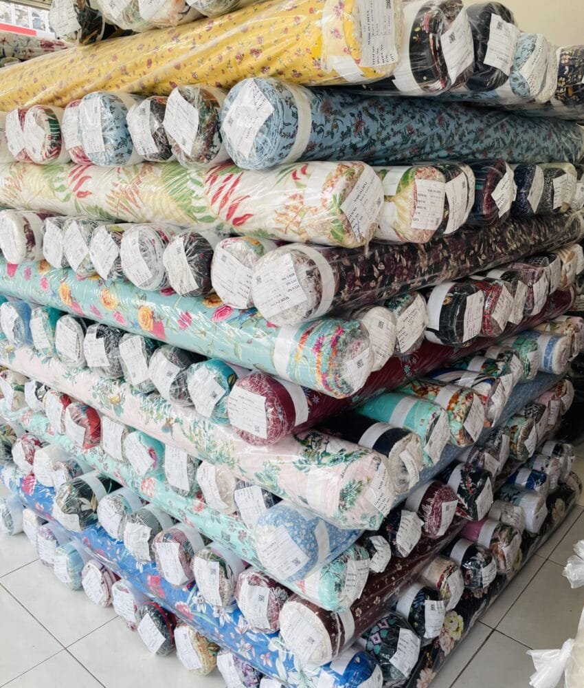 Close-up of fabric rolls in various colors and textures, displaying a wide selection of premium textiles for fashion and design.