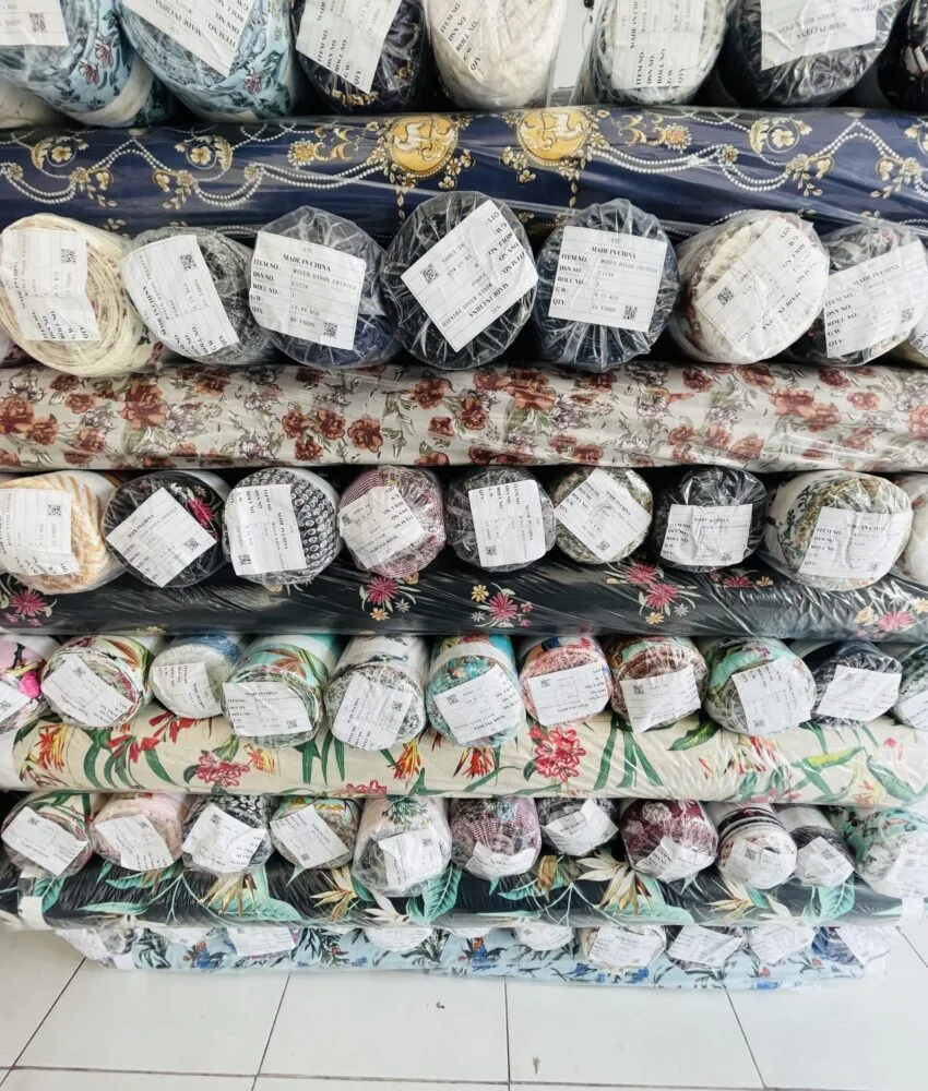 Close-up of fabric rolls in various colors and textures, displaying a wide selection of premium textiles for fashion and design.