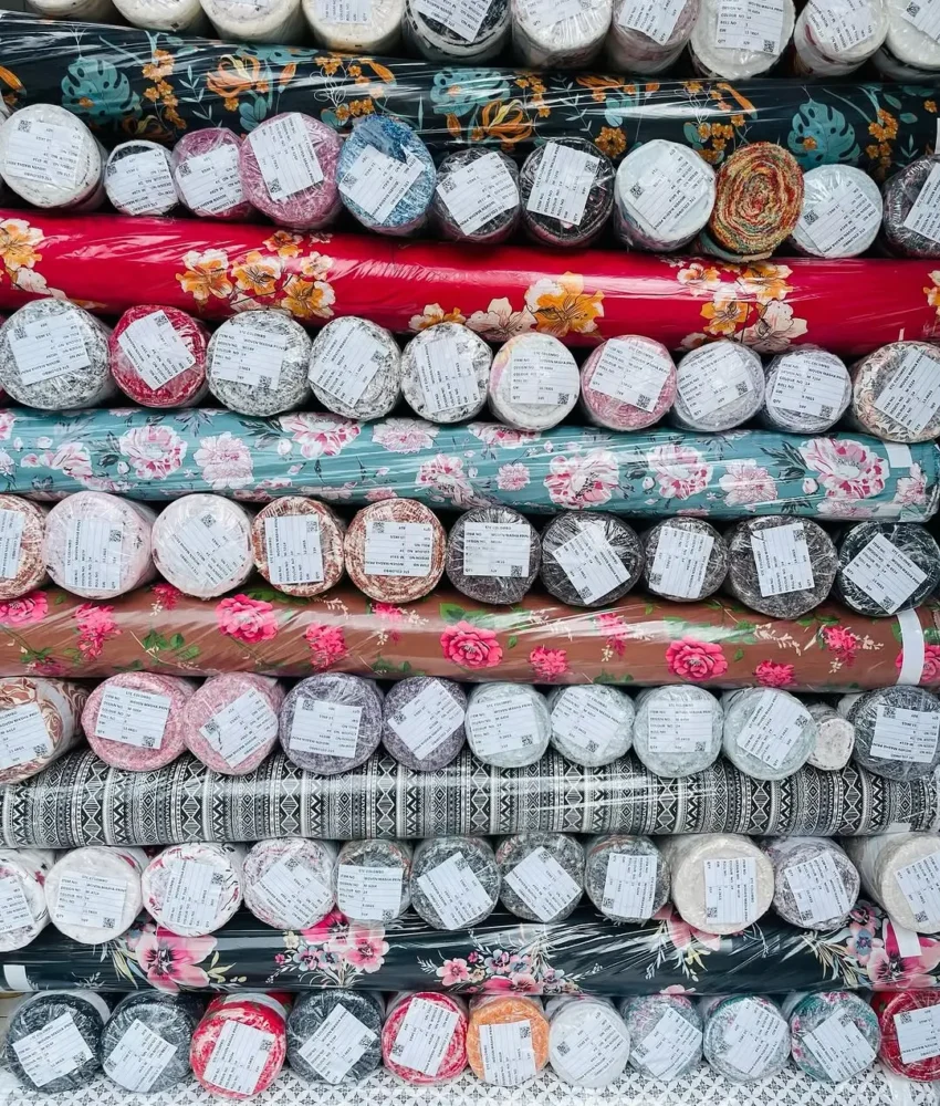 Close-up of fabric rolls in various colors and textures, displaying a wide selection of premium textiles for fashion and design.