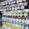 Close-up of fabric rolls in various colors and textures, displaying a wide selection of premium textiles for fashion and design.