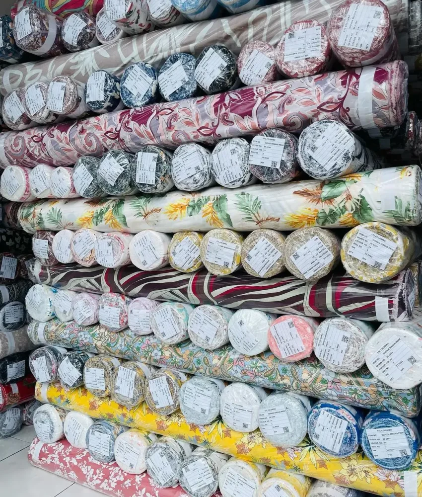 Close-up of fabric rolls in various colors and textures, displaying a wide selection of premium textiles for fashion and design.