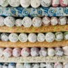 Close-up of fabric rolls in various colors and textures, displaying a wide selection of premium textiles for fashion and design.