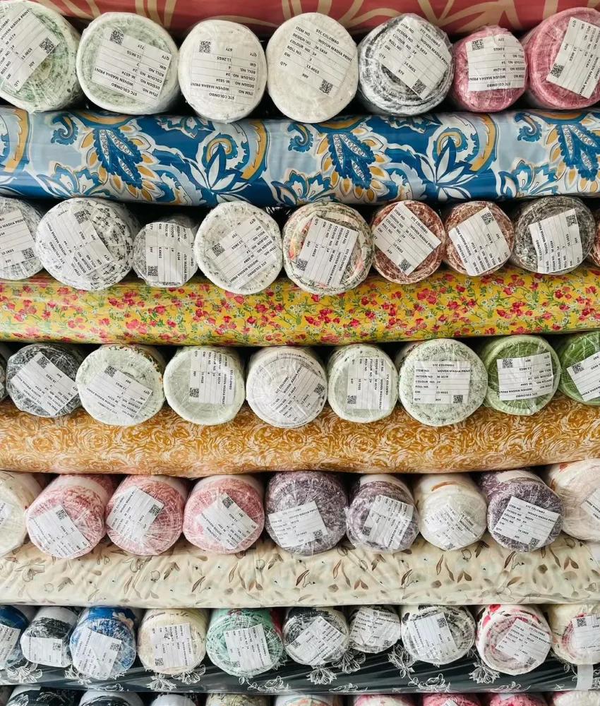 Close-up of fabric rolls in various colors and textures, displaying a wide selection of premium textiles for fashion and design.