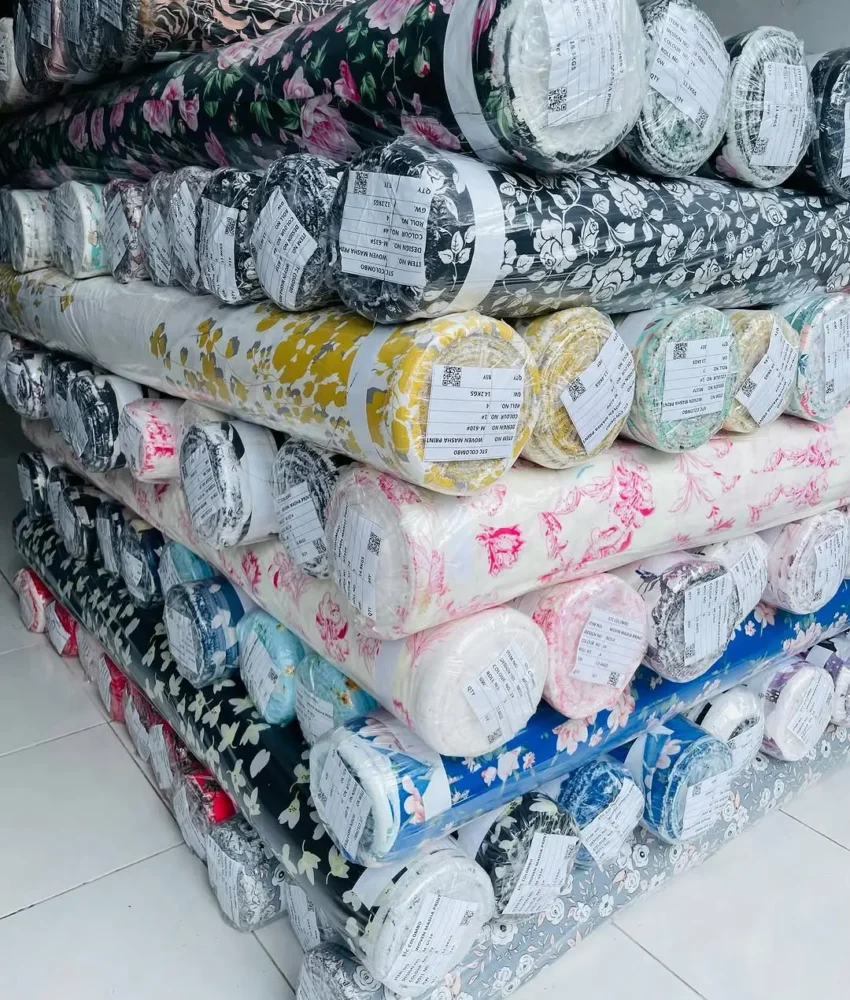 Close-up of fabric rolls in various colors and textures, displaying a wide selection of premium textiles for fashion and design.