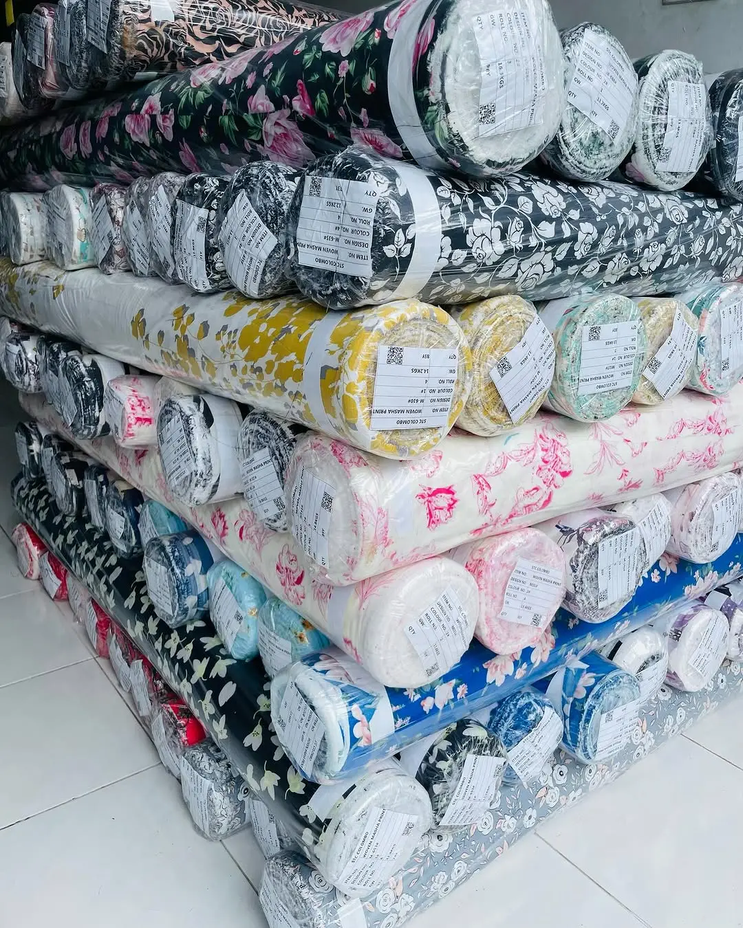 Close-up of fabric rolls in various colors and textures, displaying a wide selection of premium textiles for fashion and design.